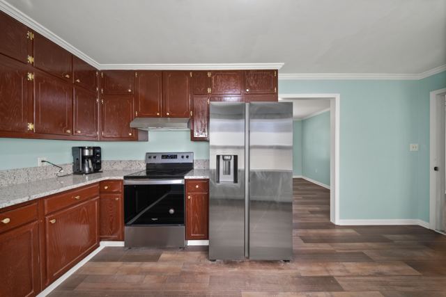 Kitchen with granite counters, stained wood cabinetry and stainless appliances